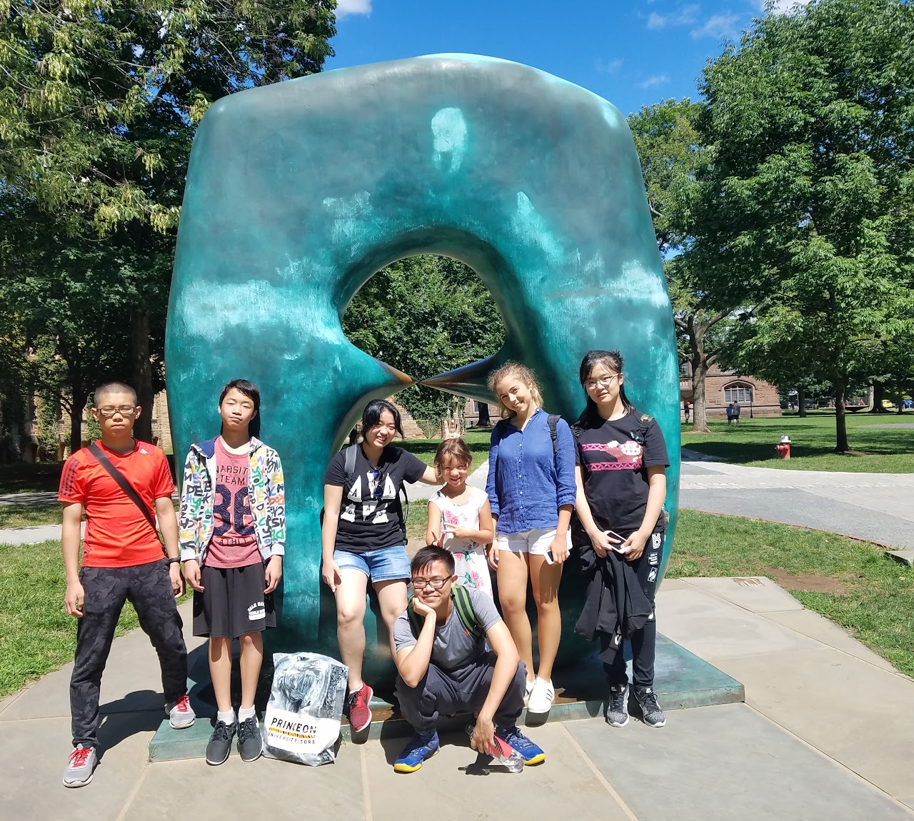 Students posing for the picture by a sculpture 