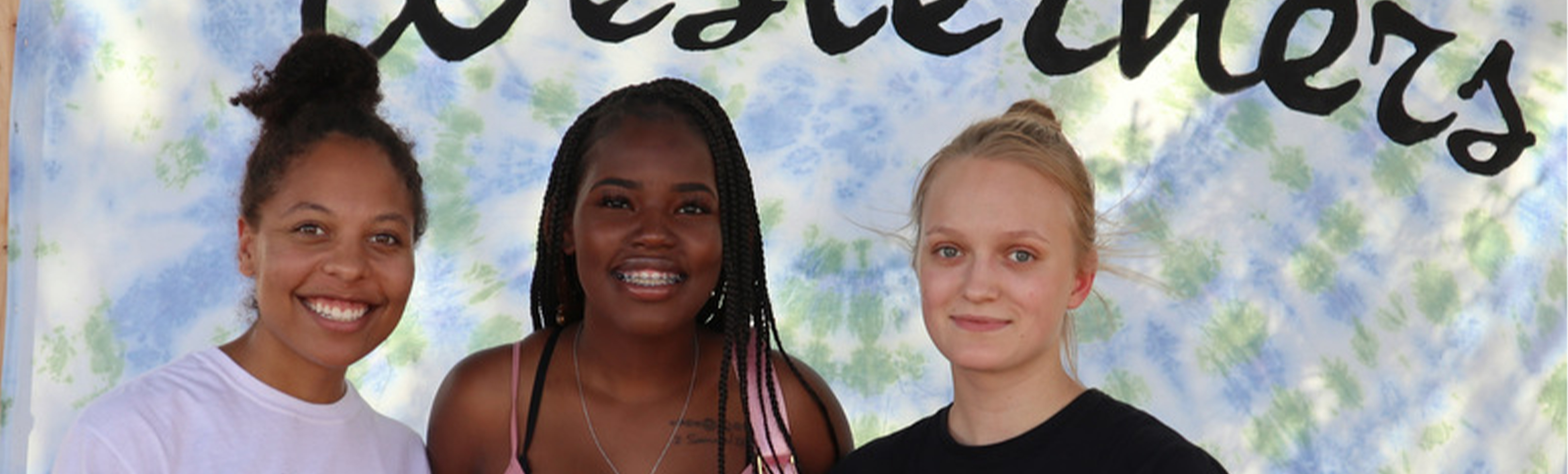 3 students in front of tie-dye background