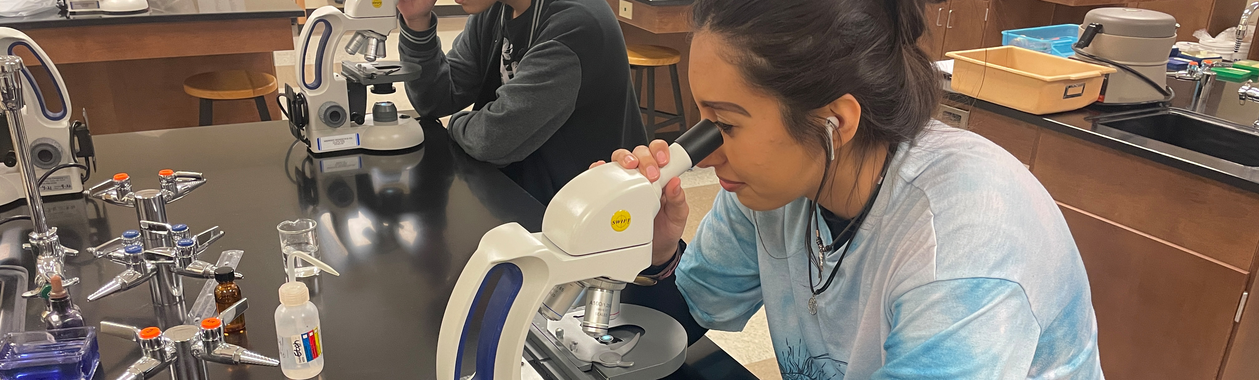Student looking through microscope
