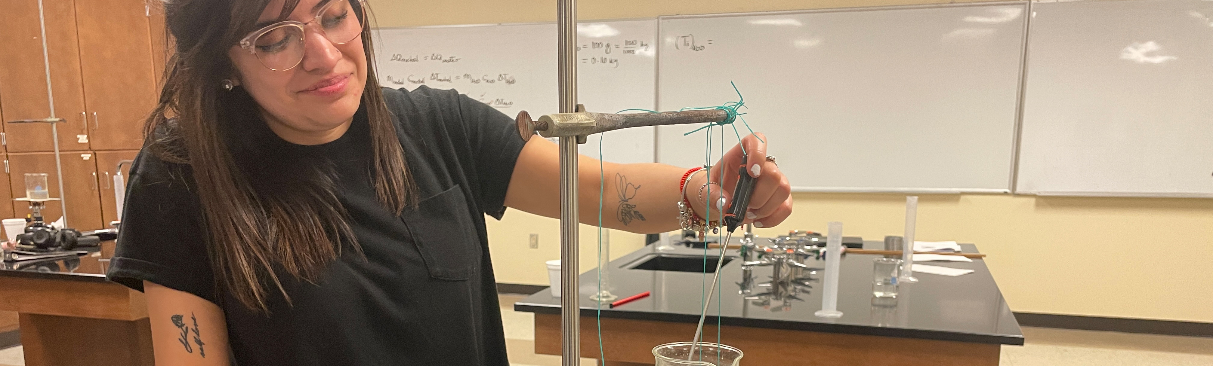 Chemistry Student stirring chemicals in beaker