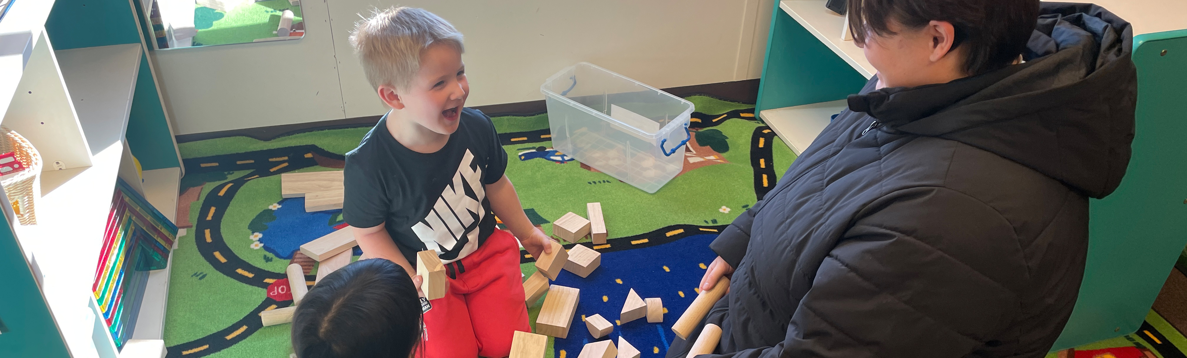 Kid playing with blocks with teacher