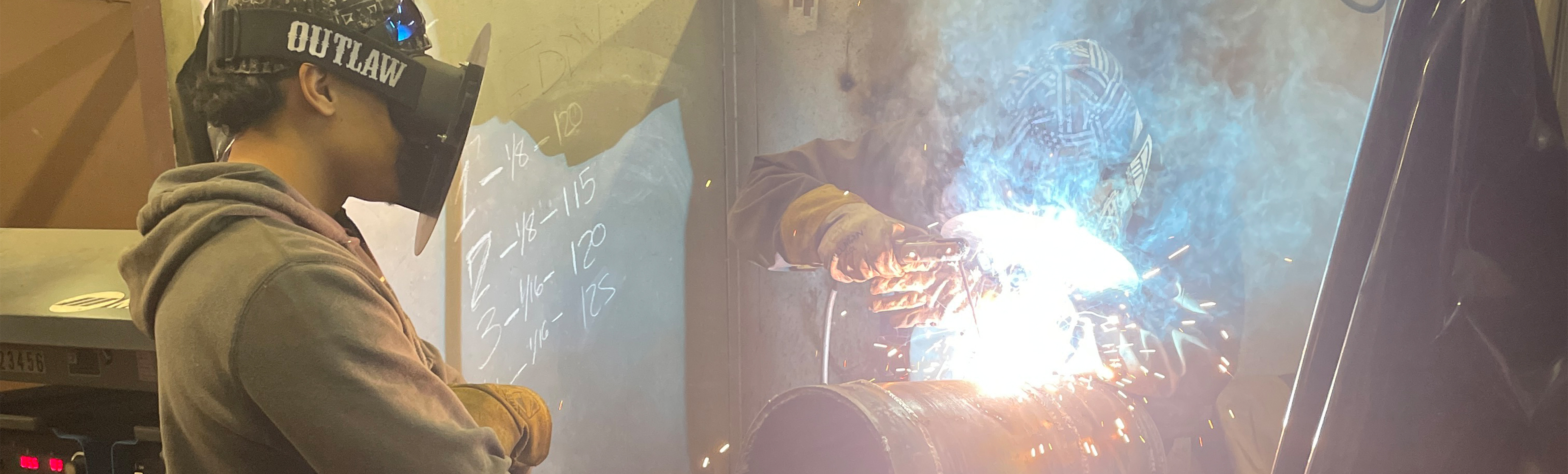 Student watching welder