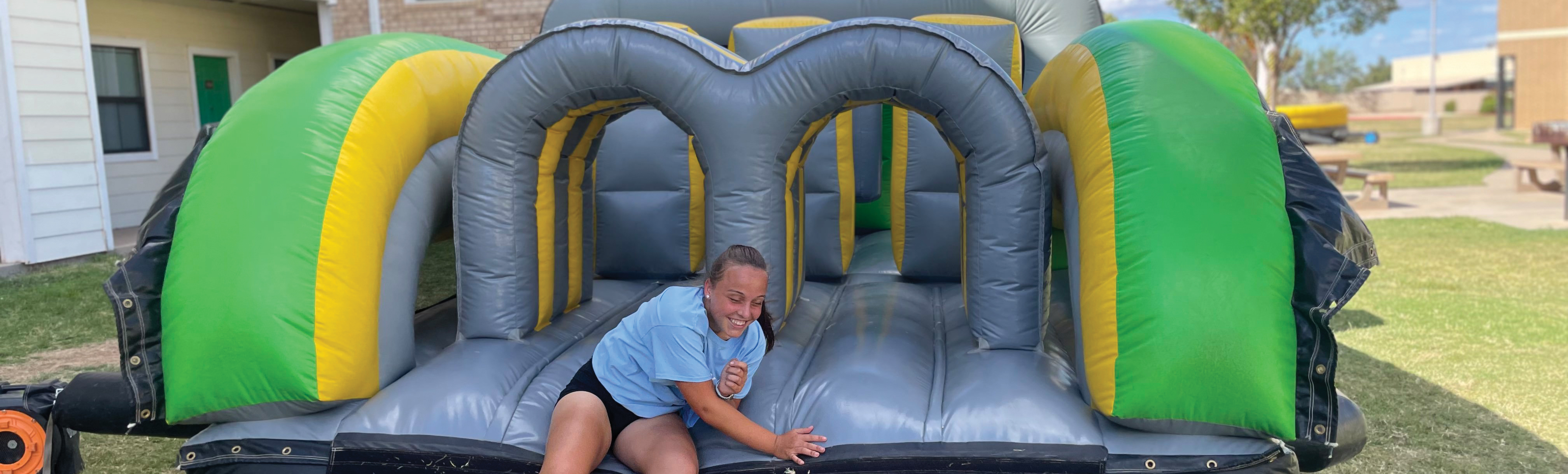 Student on bouncy house obstacle course