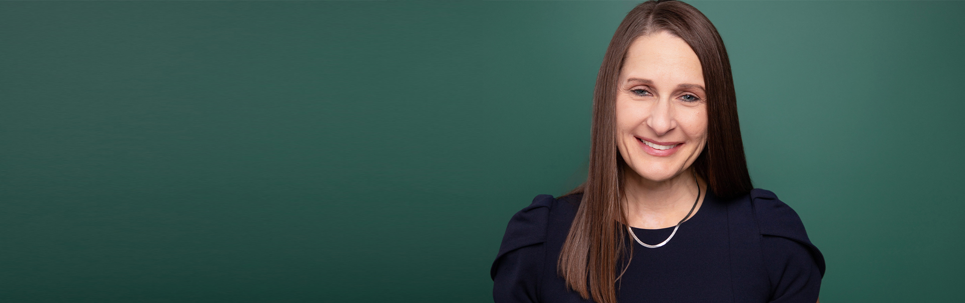 Dr. Laurie Sharp stands against a green background.
