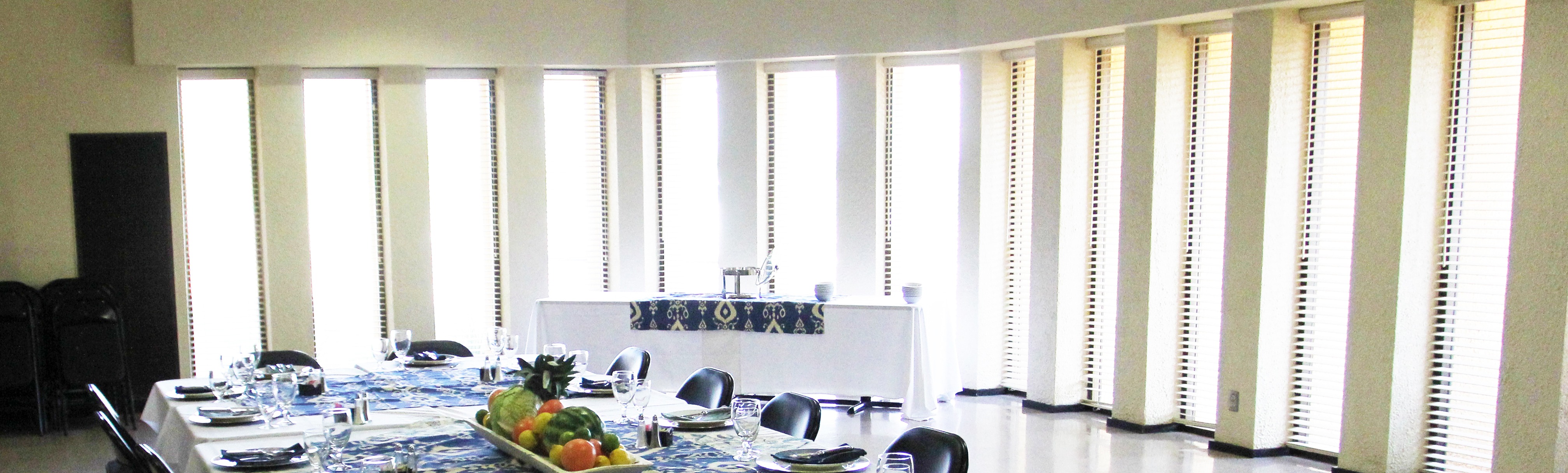 Tables set up at Visitor Center with windows that stream brigght sunshine into the room.