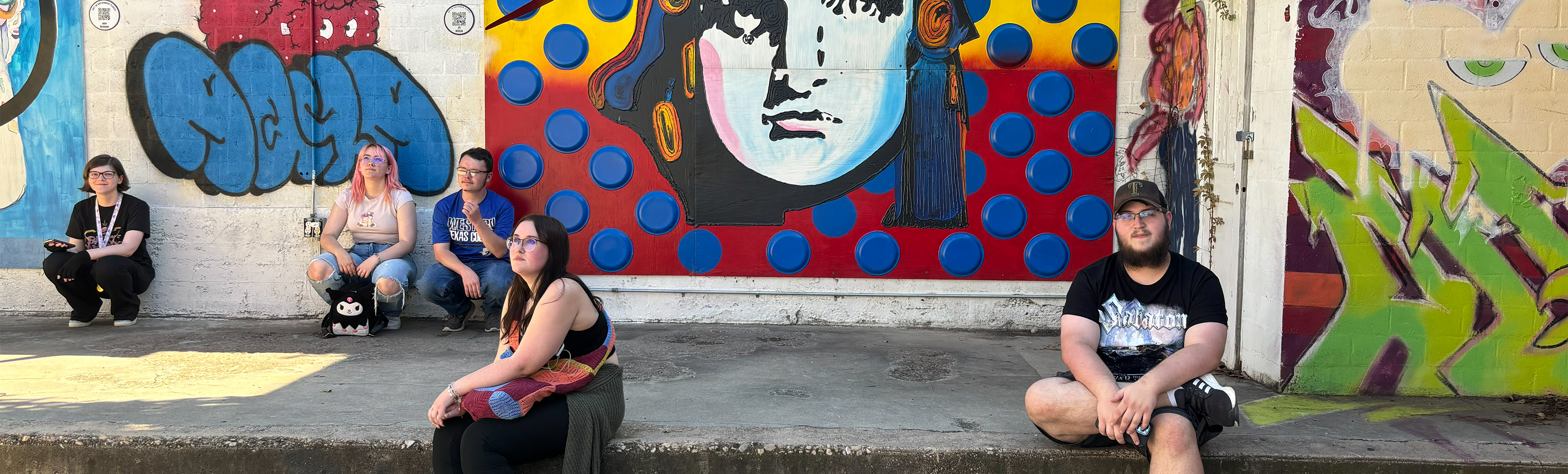 Students posing in front of art pieces