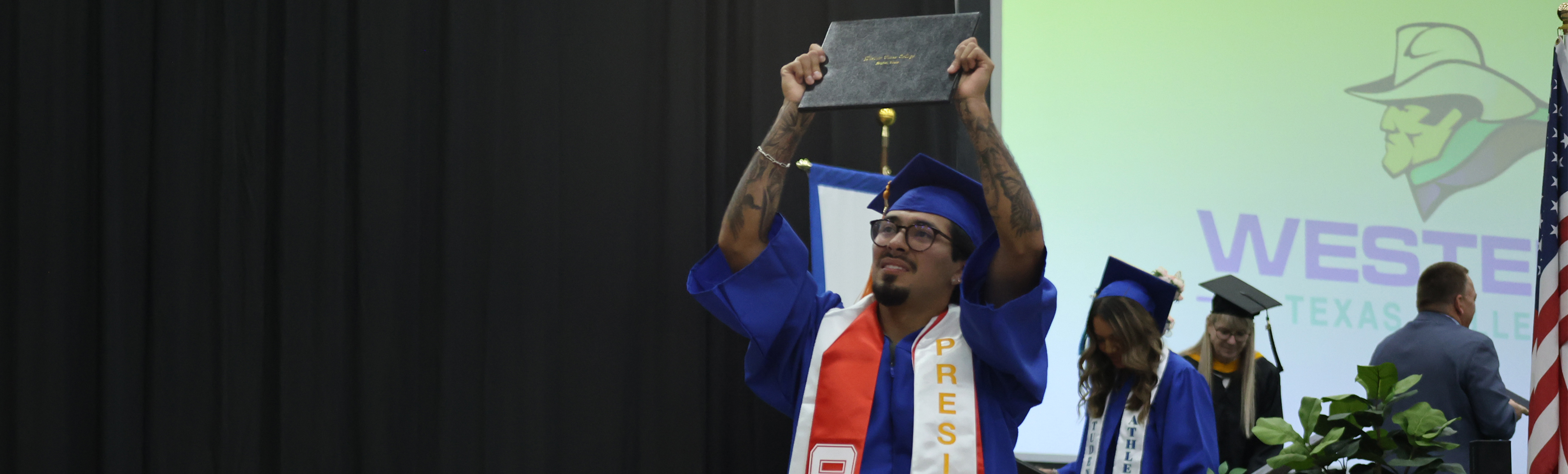 Student holding degree up at graduation