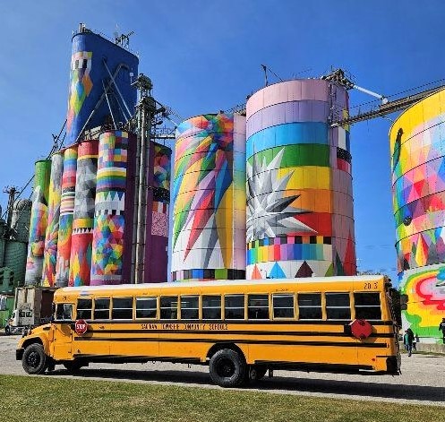 school bus in front of art silos