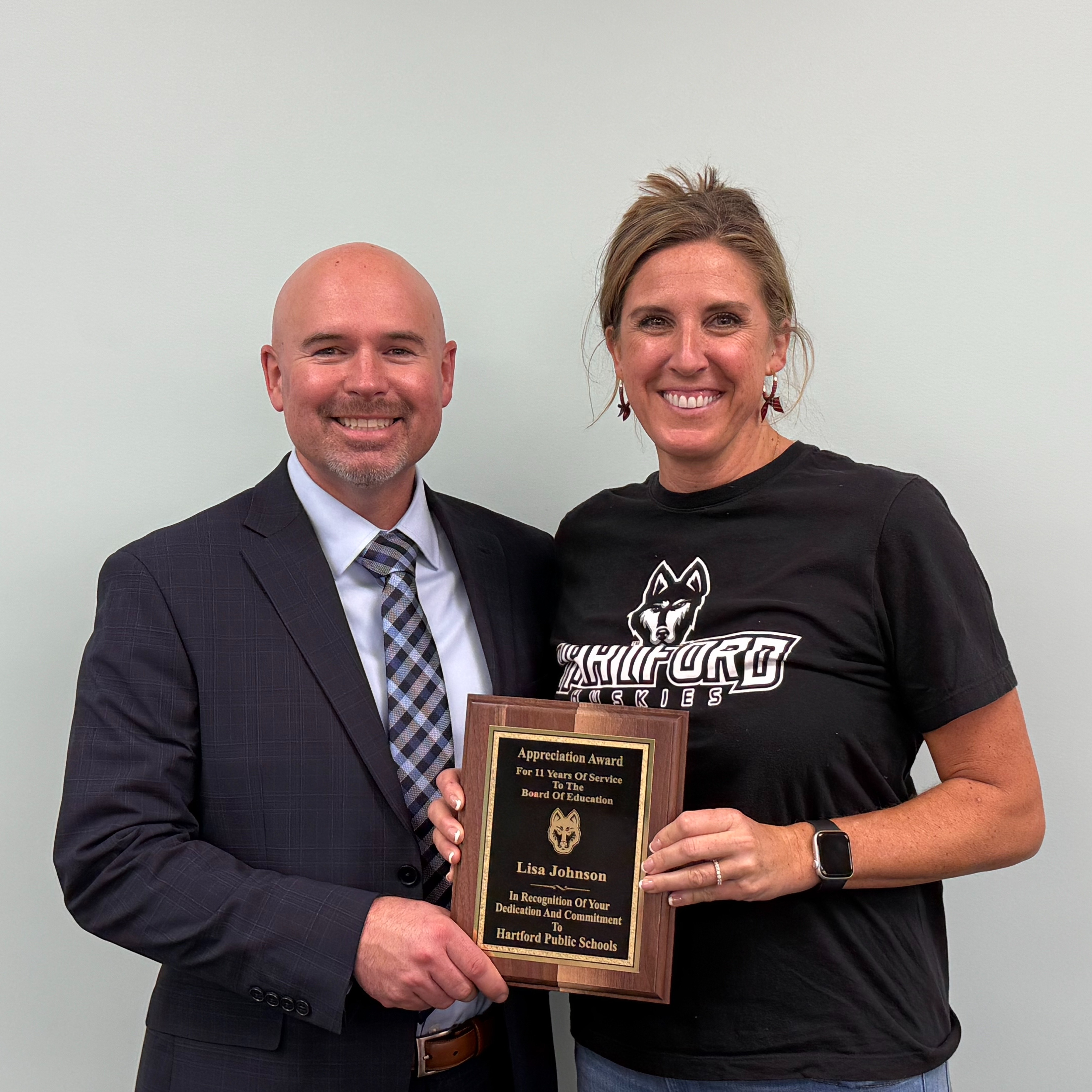 school board treasurer lisa johnson receives her appreciation award from  superintendent nick blackmer