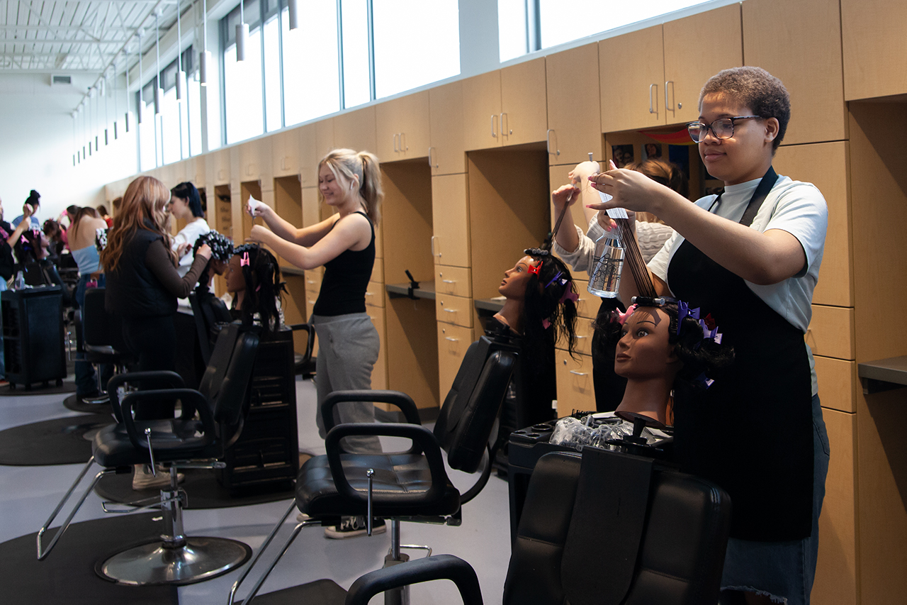 Cosmetology students working in the lab on manikin heads