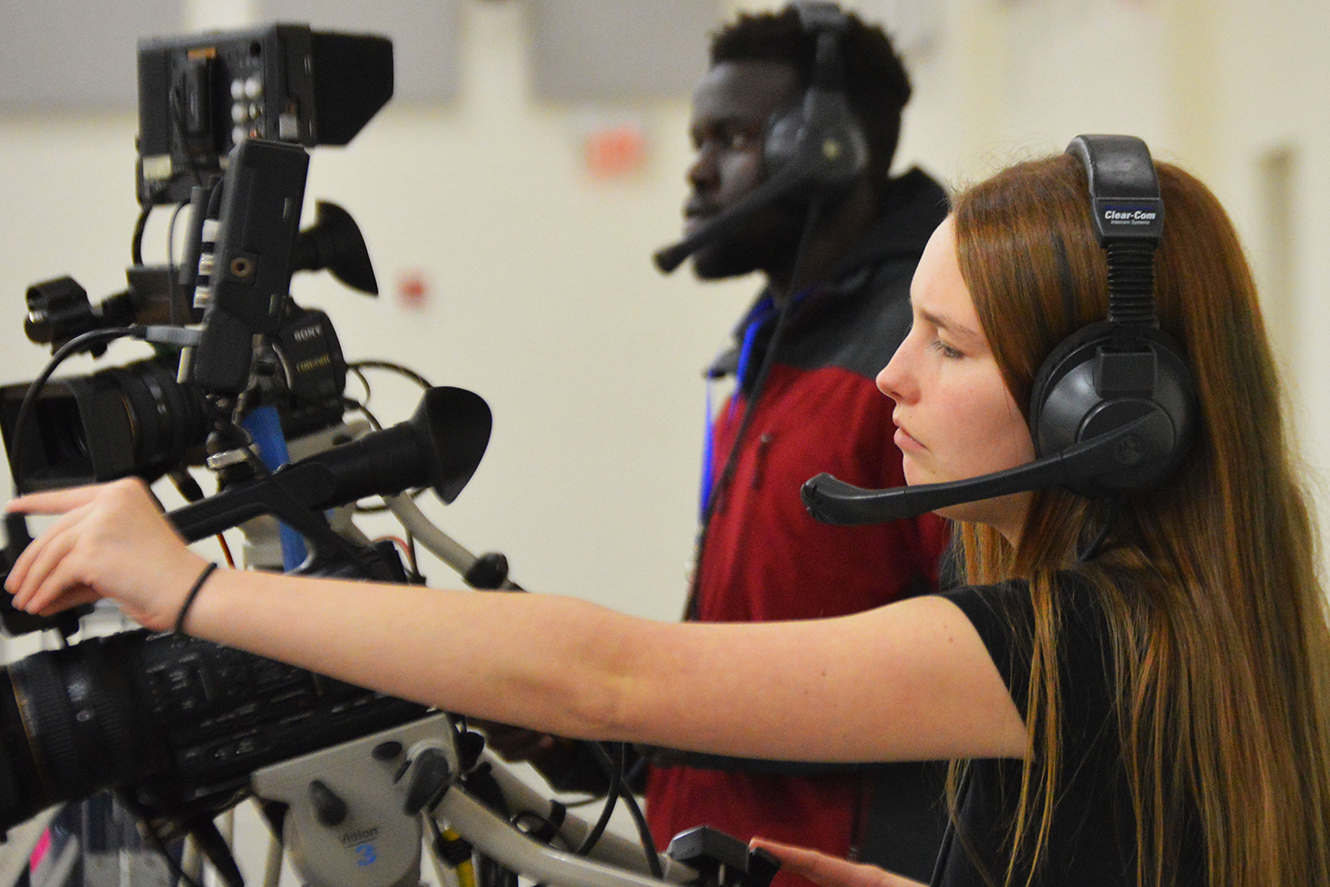 An Interactive Media student filming a production on a studio camera