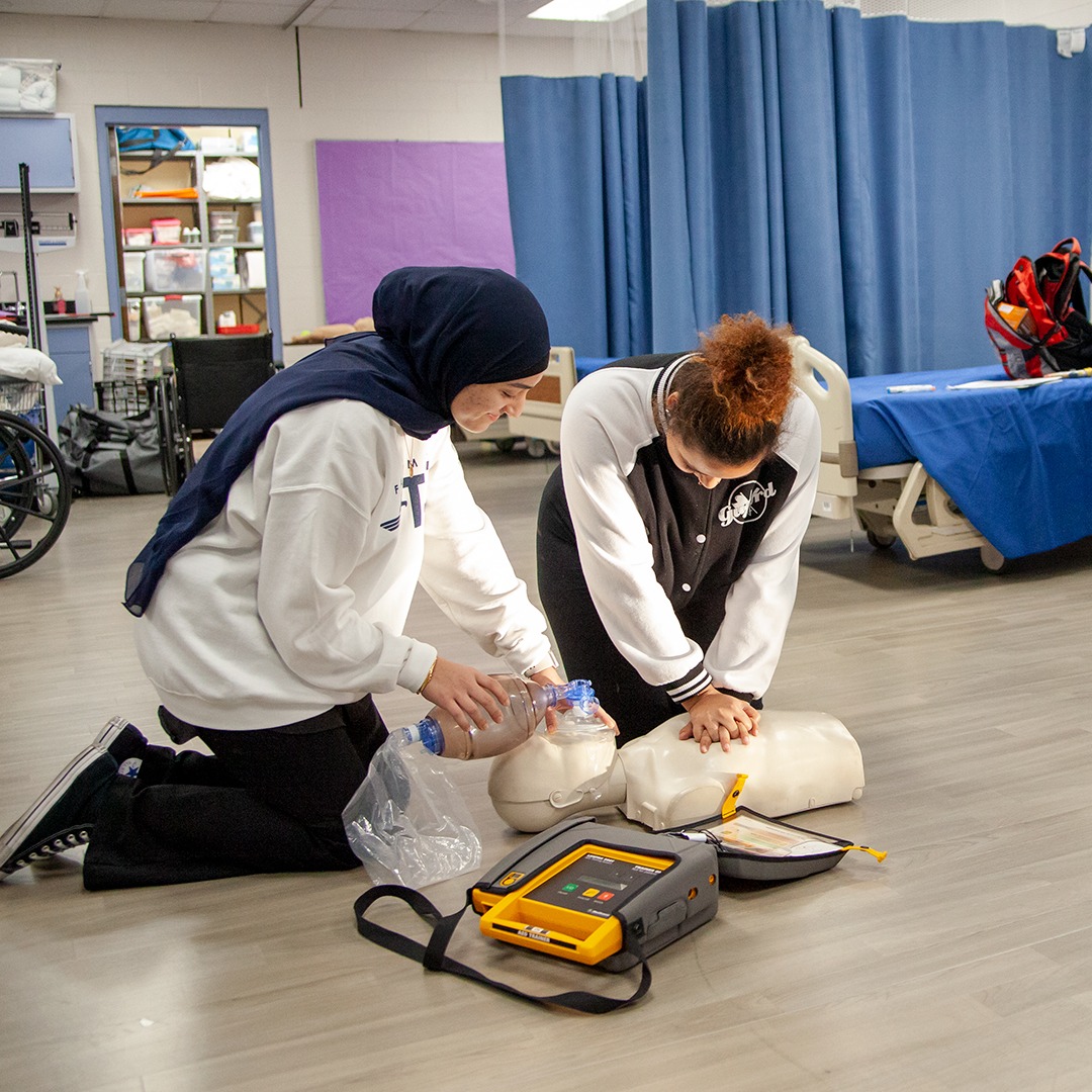 medical students performing CPR on a manikin