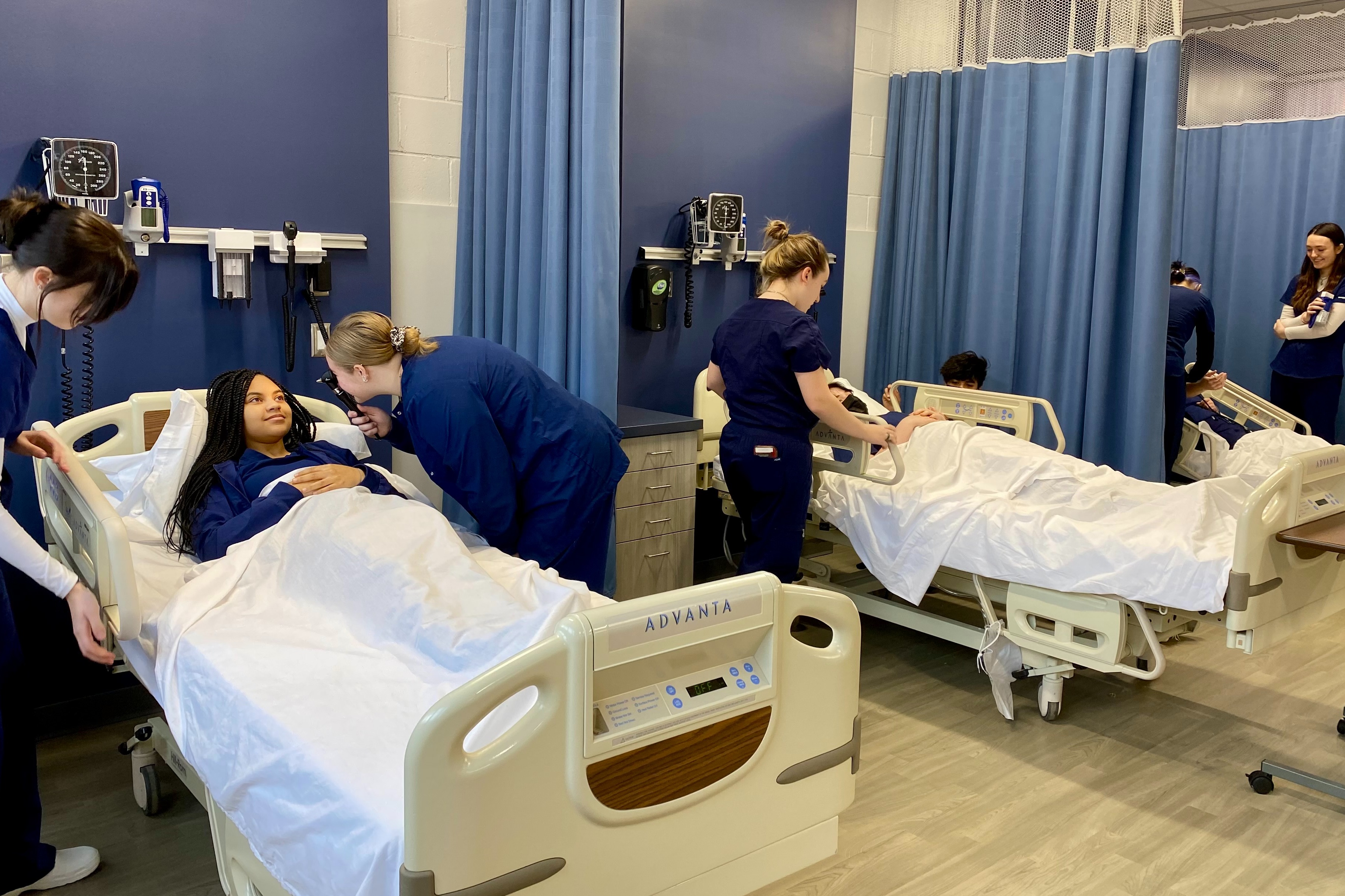 healthcare students working on practice patients in hospital beds