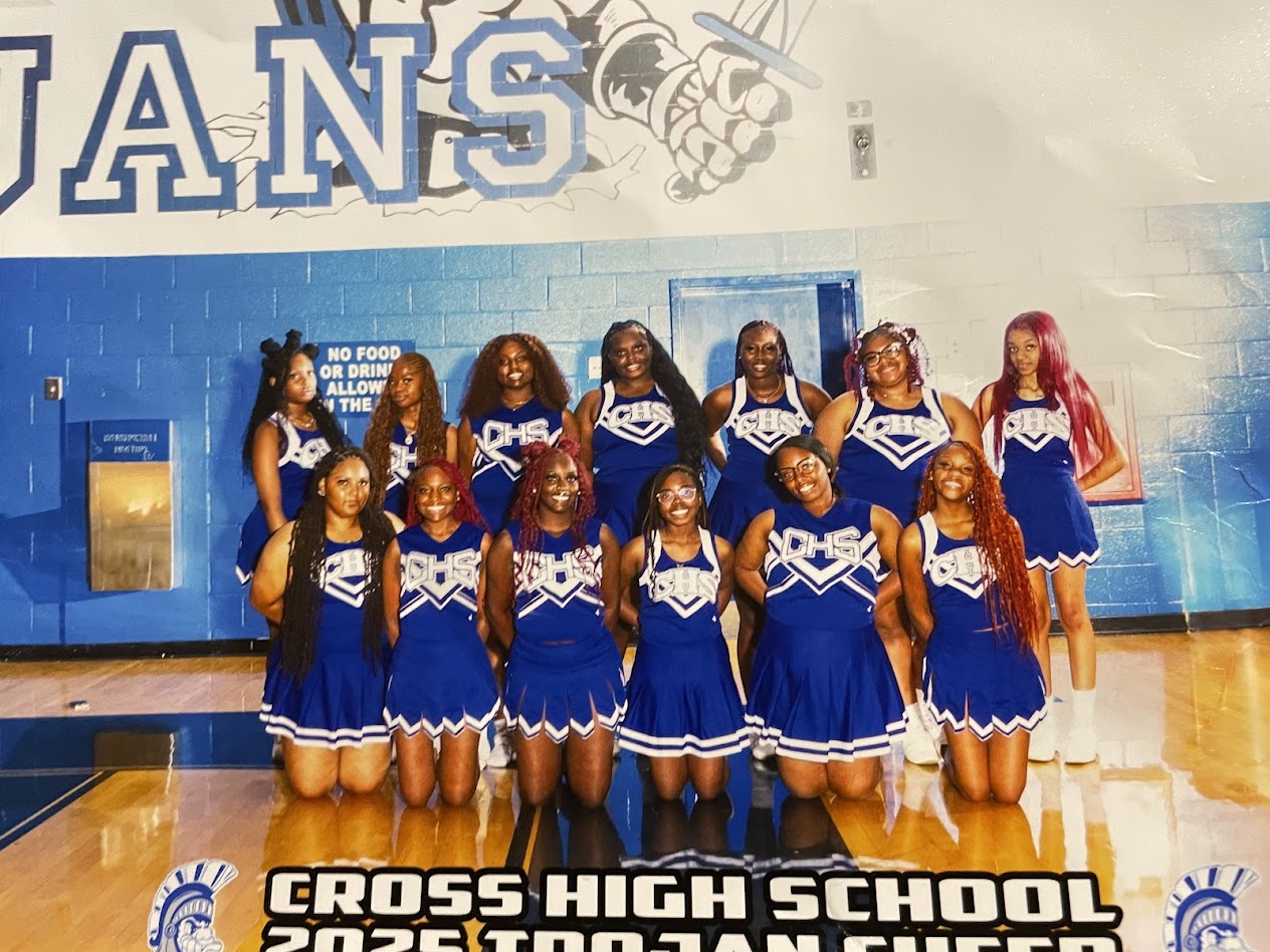 Cheerleaders from Cross High School are posing in blue uniforms on a basketball court.