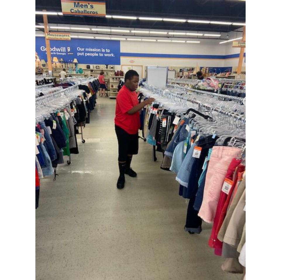 A student organizing a clothing rack