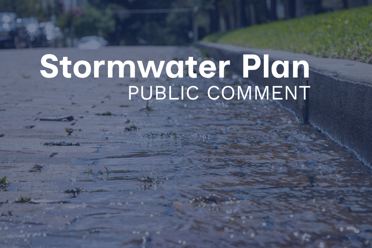 Street curb with rainwater and the text "Stormwater Plan Public Comment"