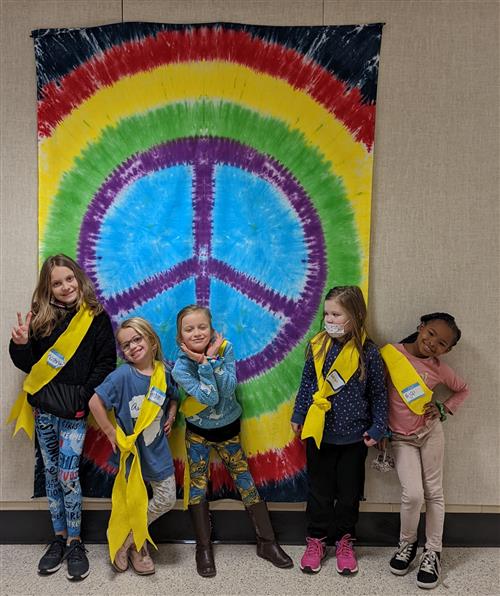 Young students posing in front of a peace sign
