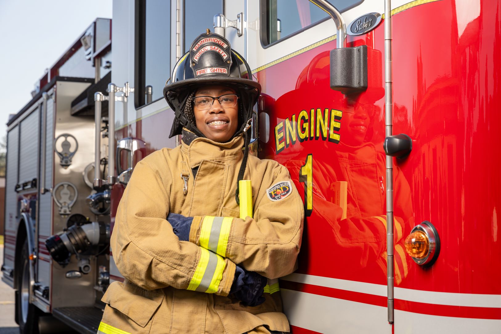 Officer by firetruck smiling