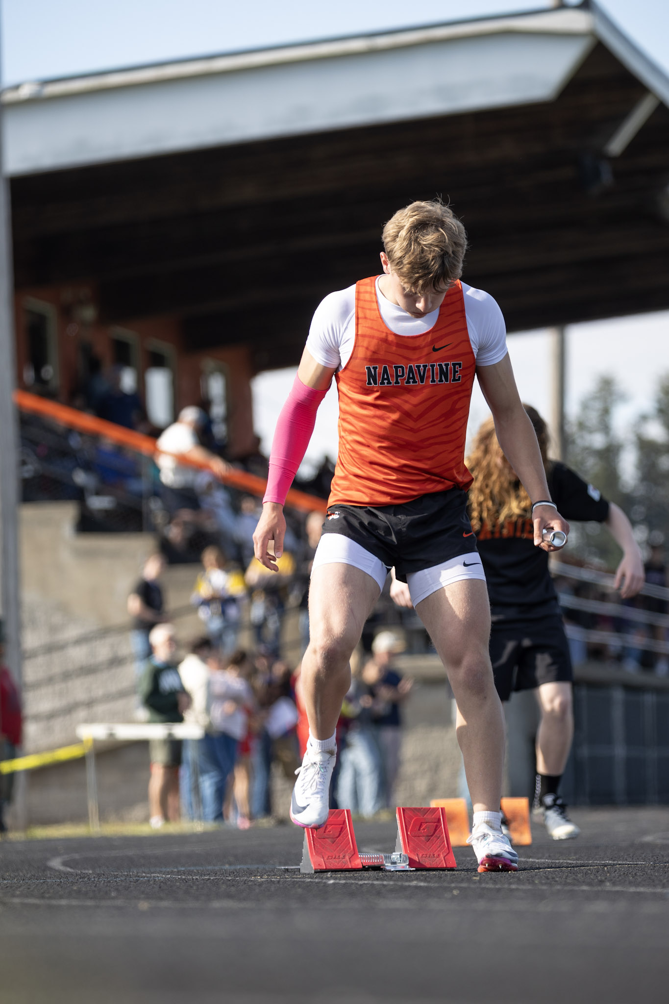 A track athlete gets in the starting blocks at a home track meet