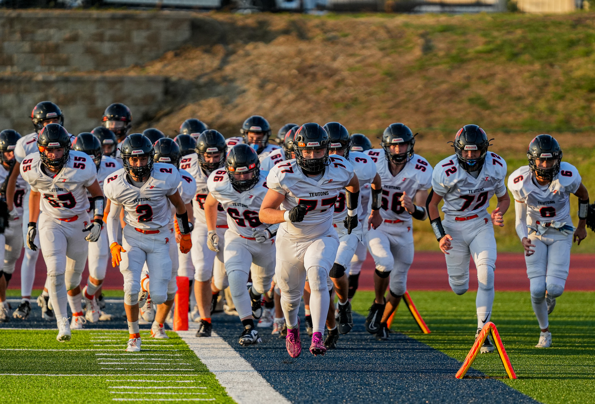 High school football team running onto the field