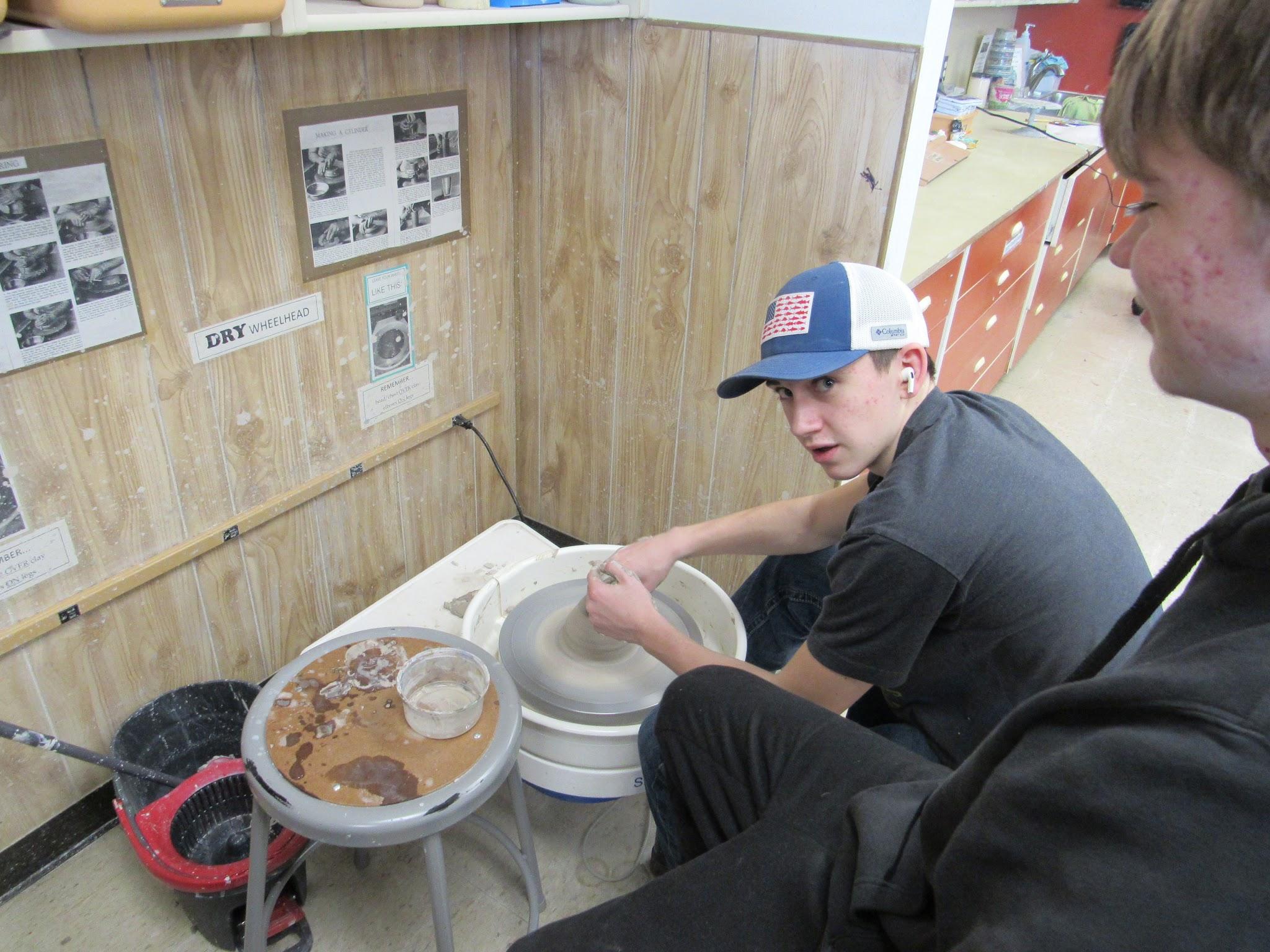 Student working with pottery wheel