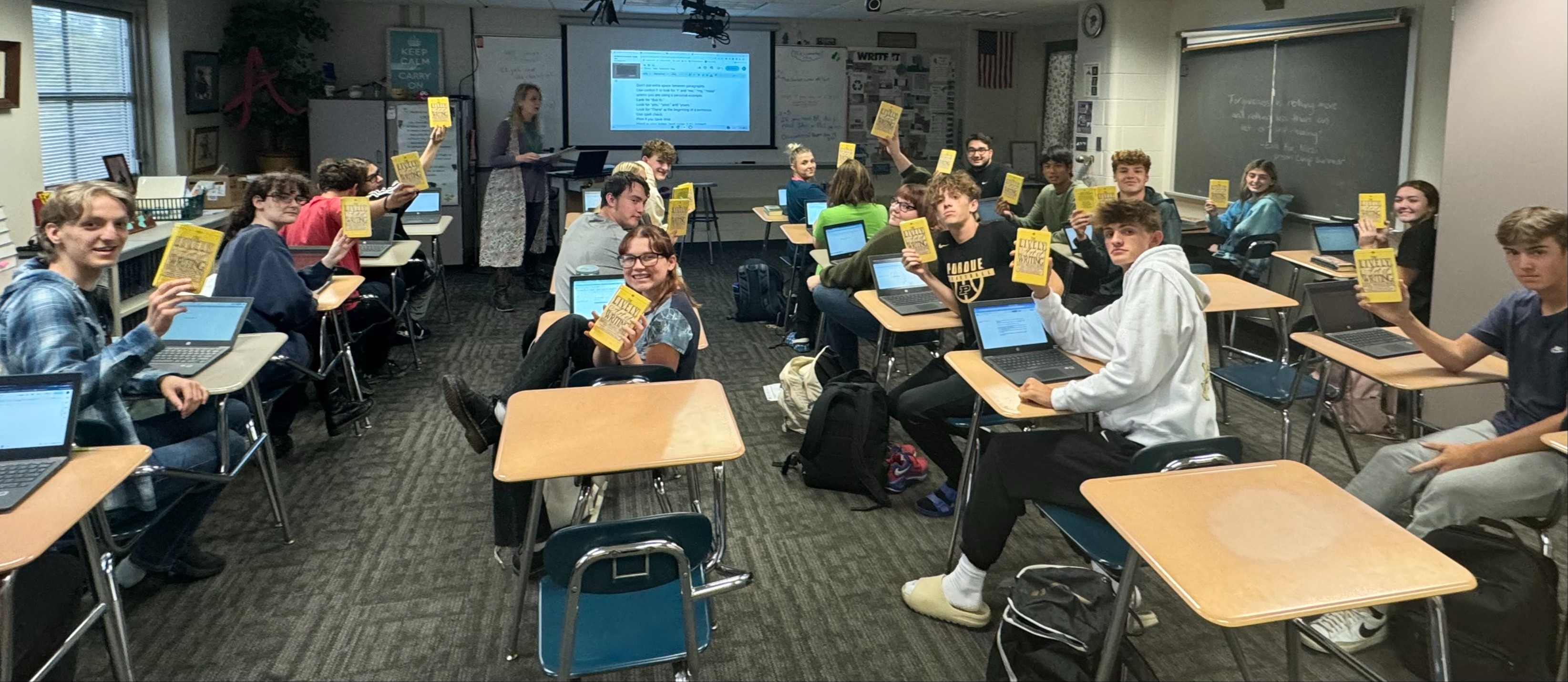 Students hold up their English writing books