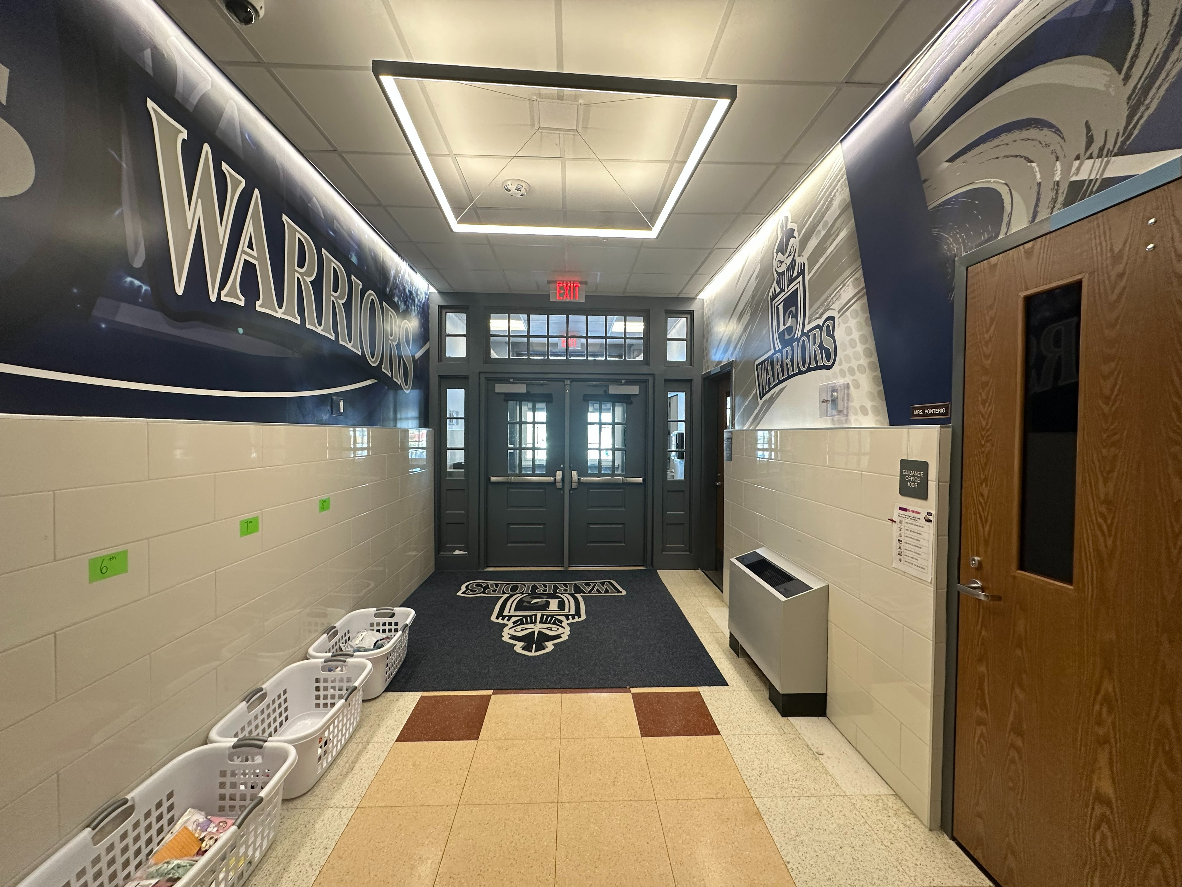 main entrance interior with tile and logos on graphics above the tiled walls