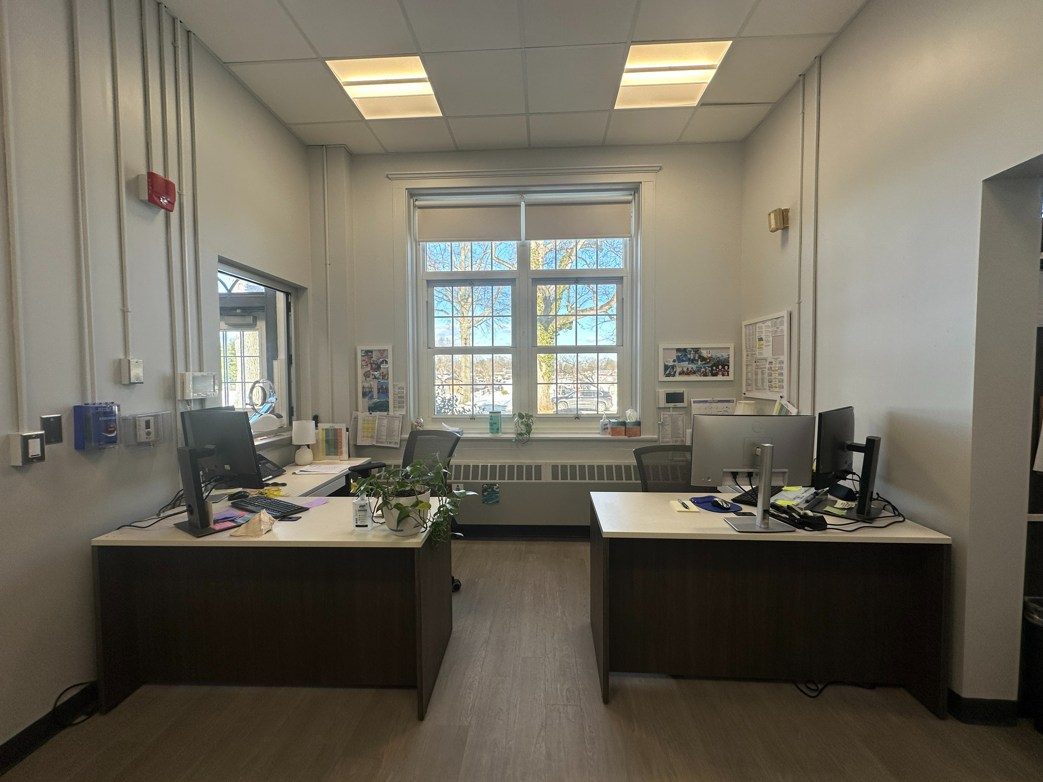 Main office with 2 desks and window between the two desks