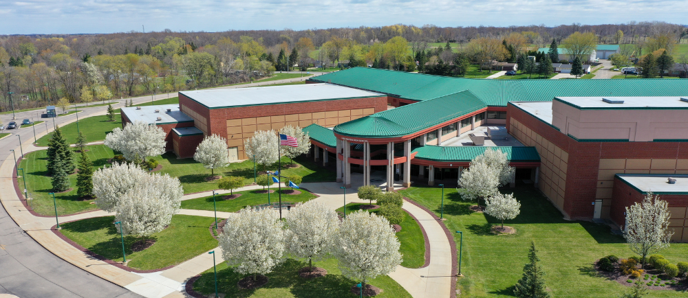 Aerial drone image of the lake fenton high school campus with trees blooming 