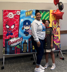 Parent and child in front of a superhero backdrop