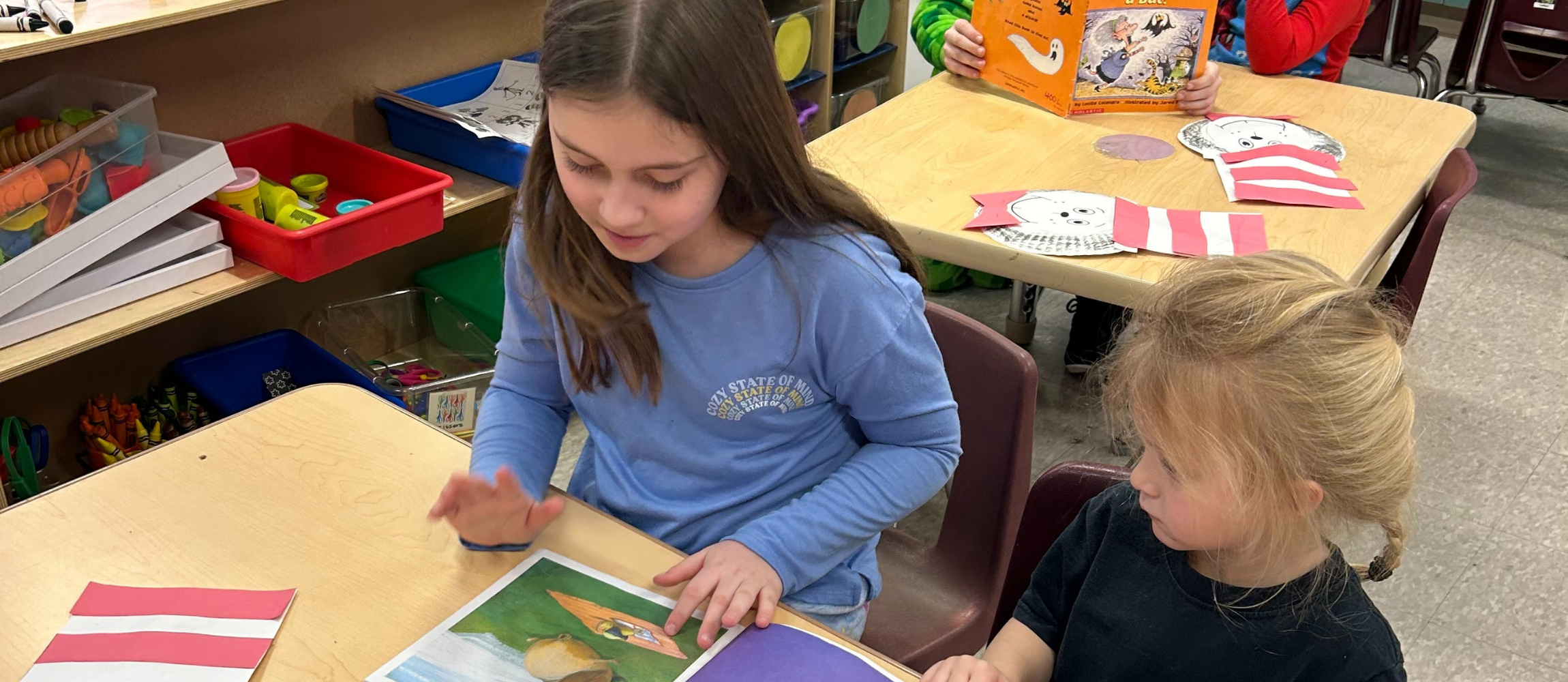 older girl reading to younger girl