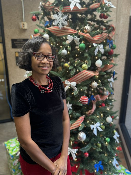 Picture of Ms. Jackson in front of Christmas Tree
