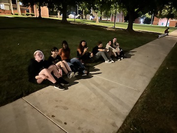 Team members and friends sitting on the ground