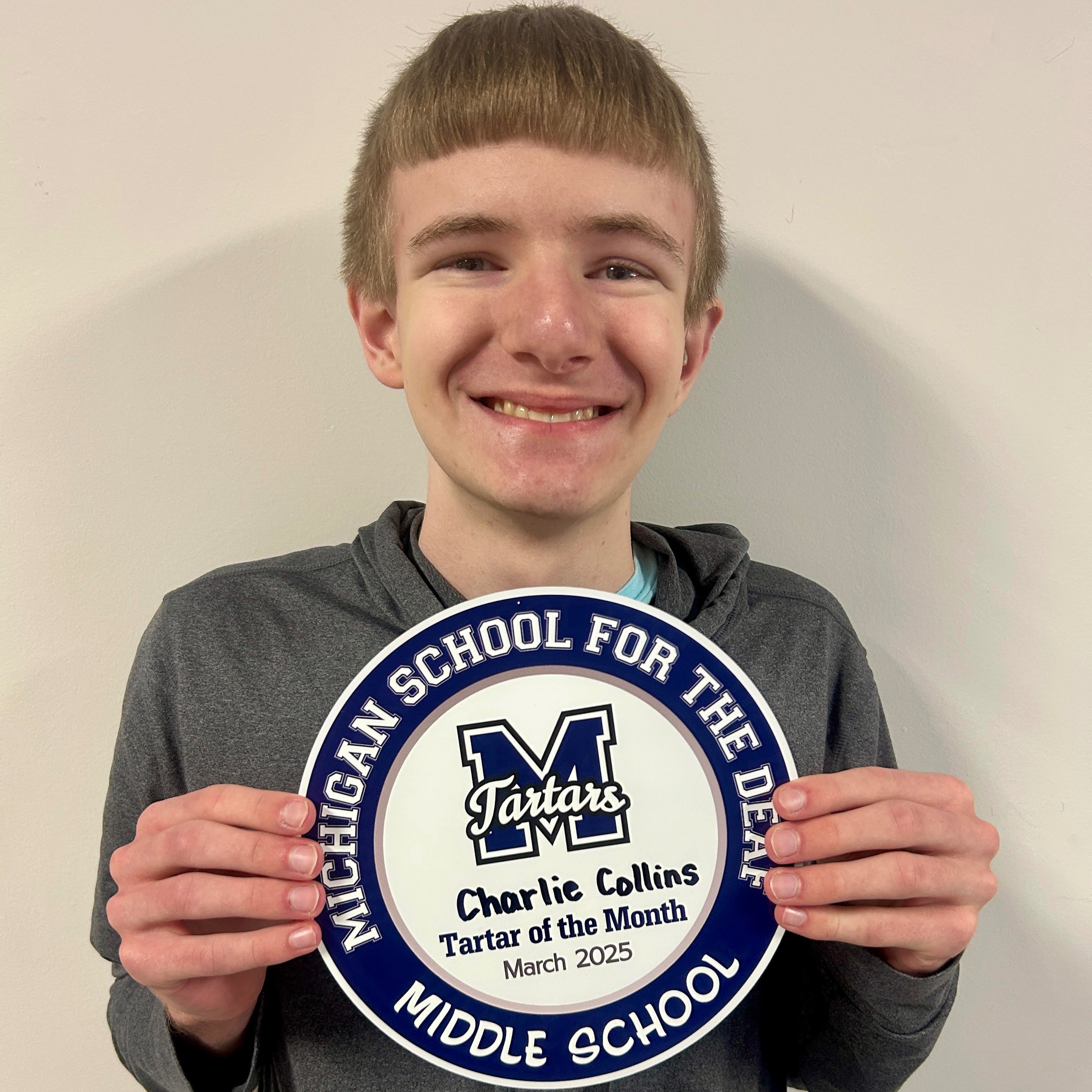 Charlie Collins holding a plaque