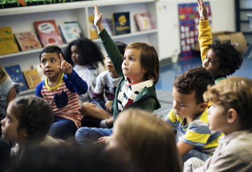 Kindergarten students raising their hands