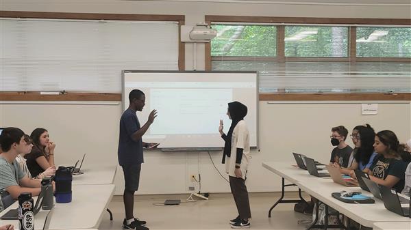 Two people doing a presentation with a projector 