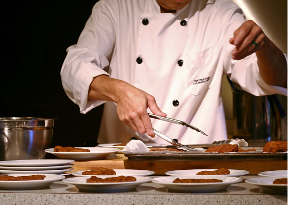 Chef picking up dish with tongs