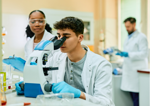 Medical students looking through microscope