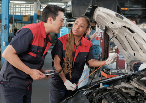 2 people checking under the hood