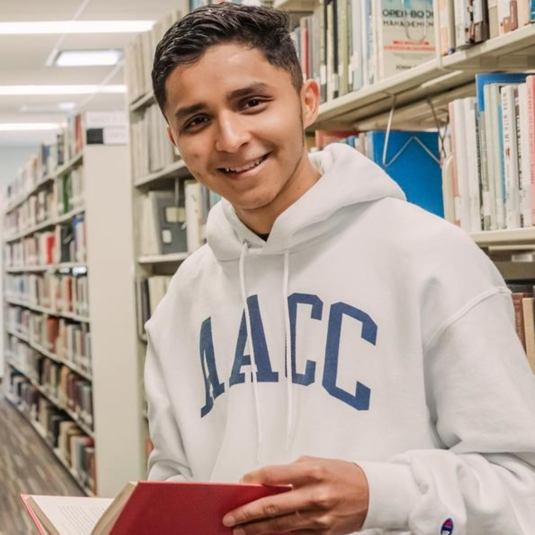 Student studying in library with AACC sweatshirt