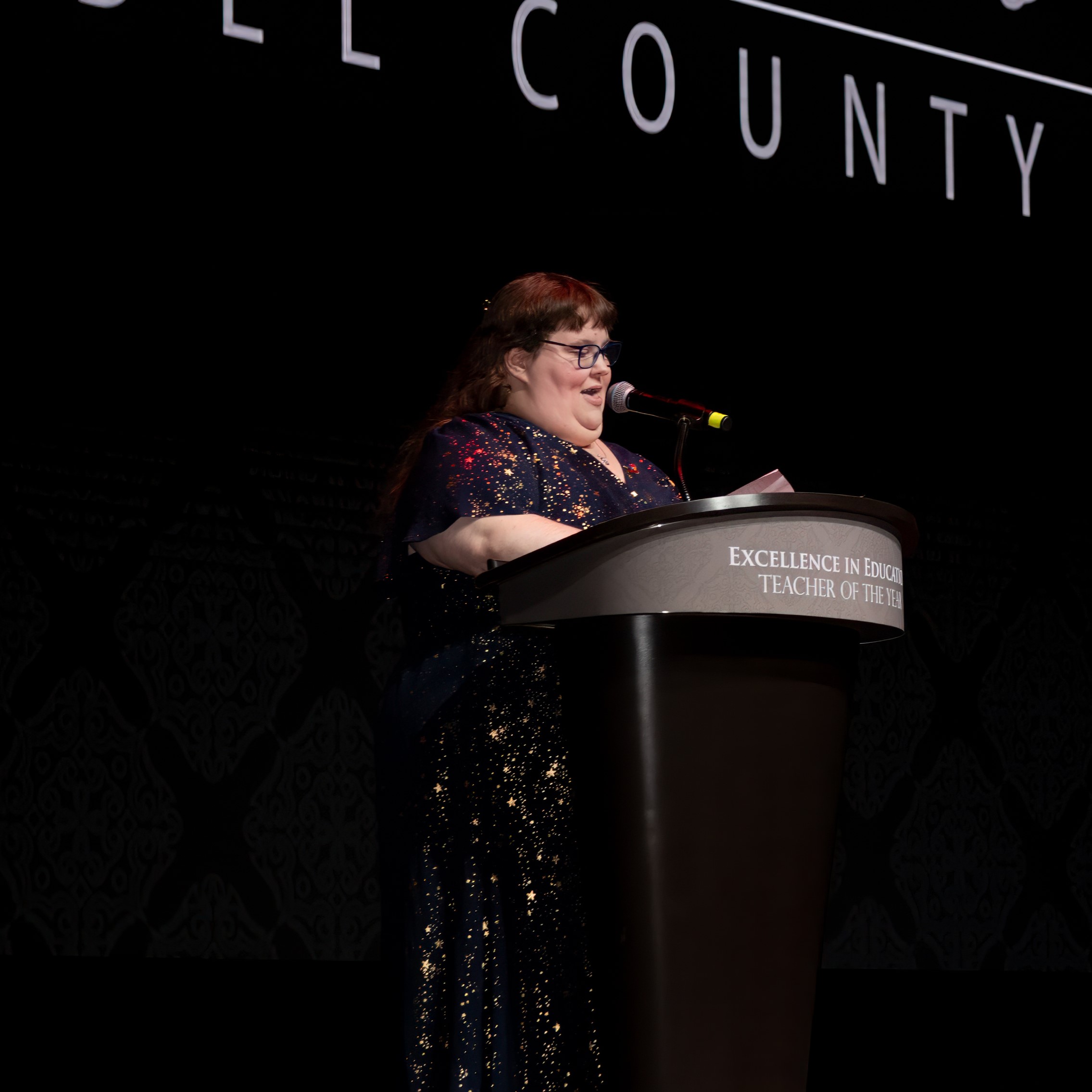 Photo of Elizabeth Heist, the 2024 Teacher of the Year, speaking at a podium giving her acceptance speech.