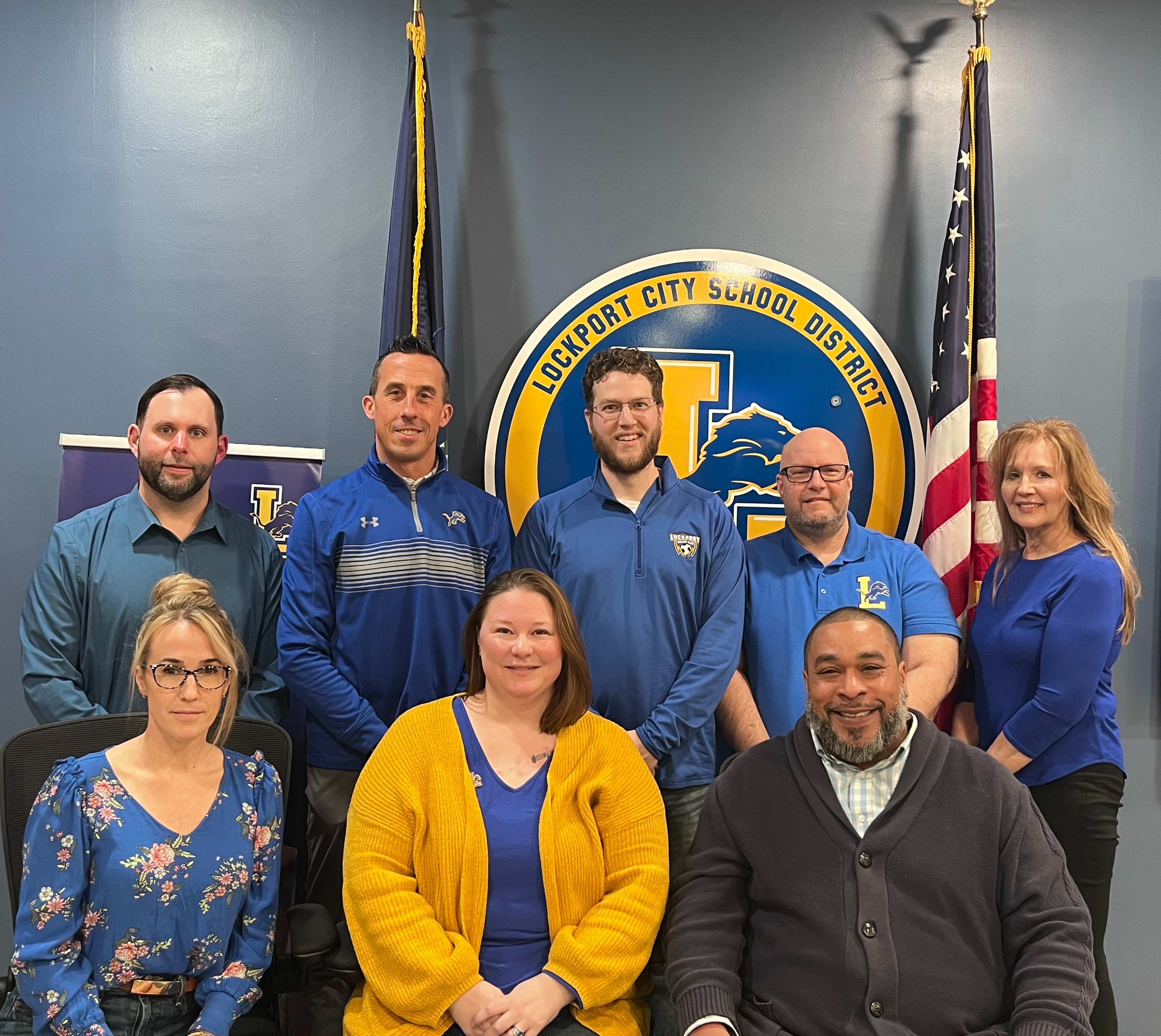 10 School board members smiling all together in a room