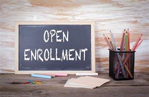 An image with a small chalkboard reading "Open enrollment" next to a pencil holder