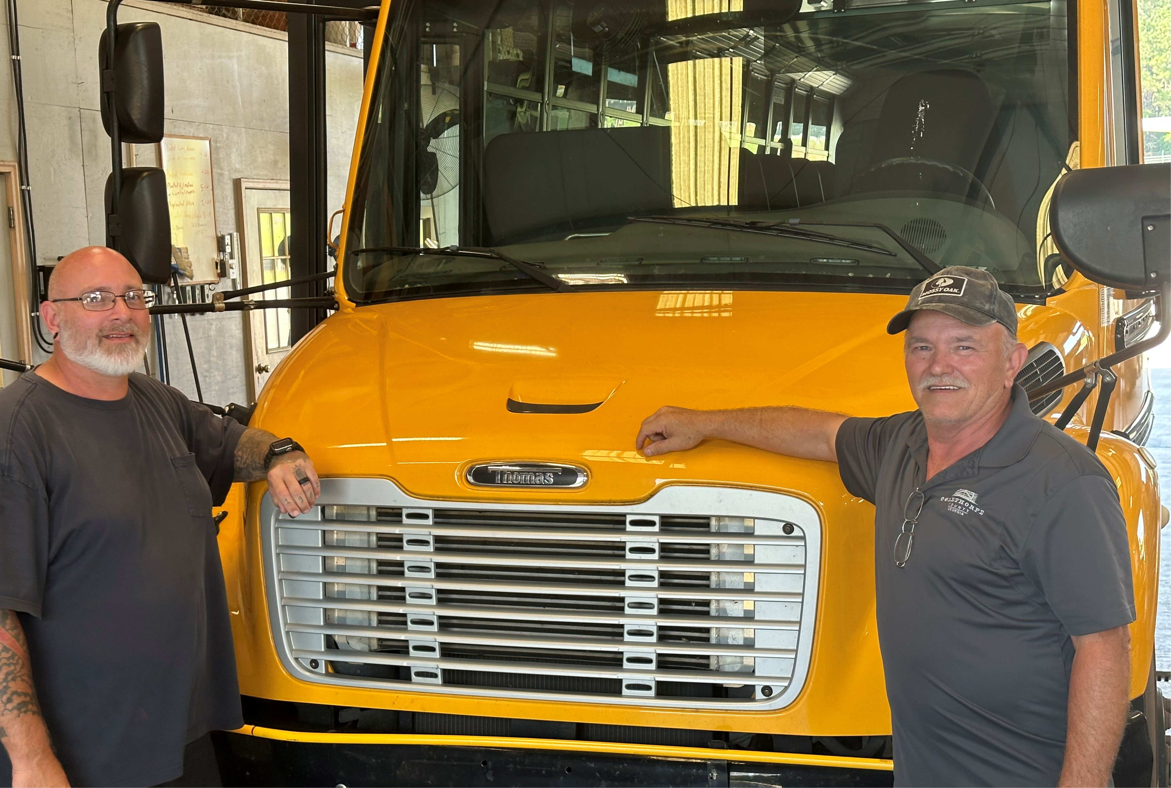 two men in front of bus