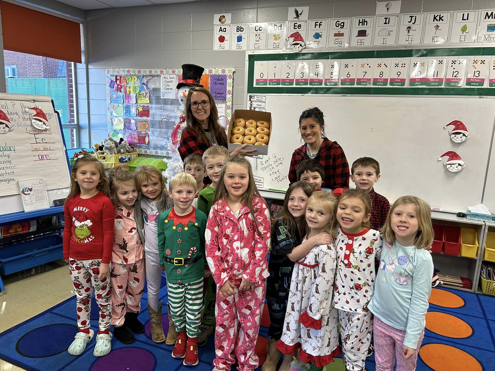 students in pajamas with donuts