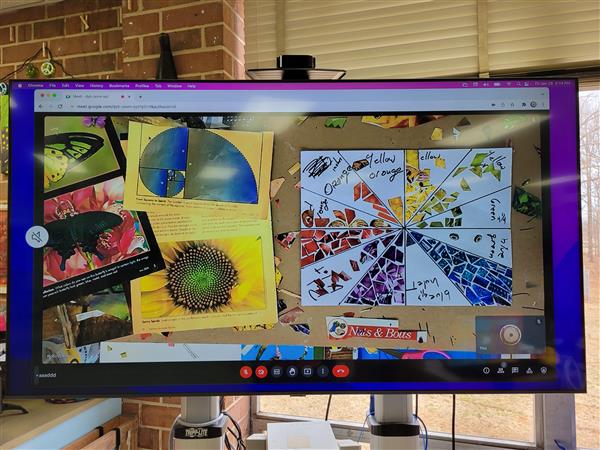 A vibrant presentation screen displaying an assortment of colorful art and images, likely in a classroom or office setting.