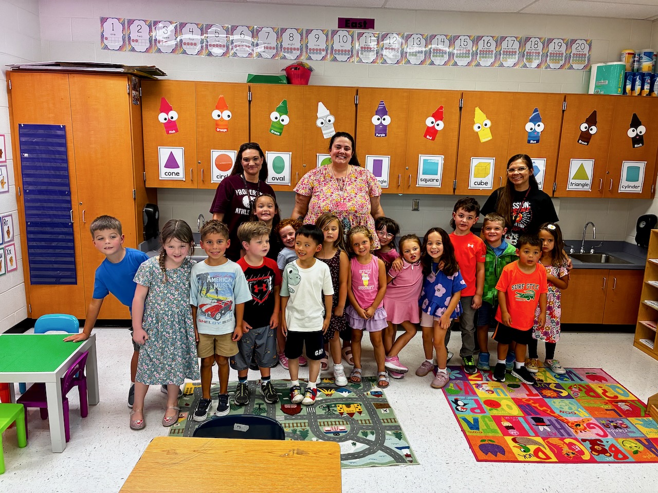 Kindergarten class smiling with their teacher