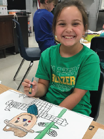 a little student girls working on her painting smiling to the camera