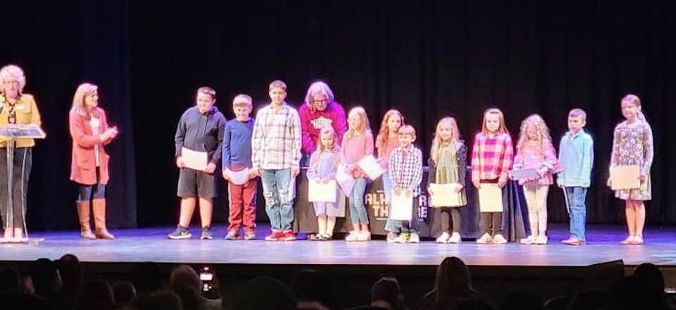 a row of little students in line receiving recognition