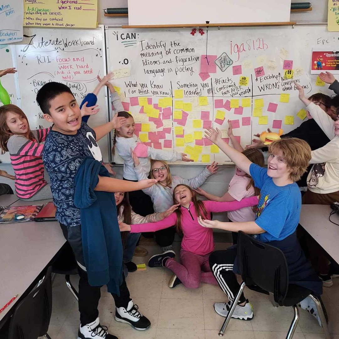 students in class pointing at a chart